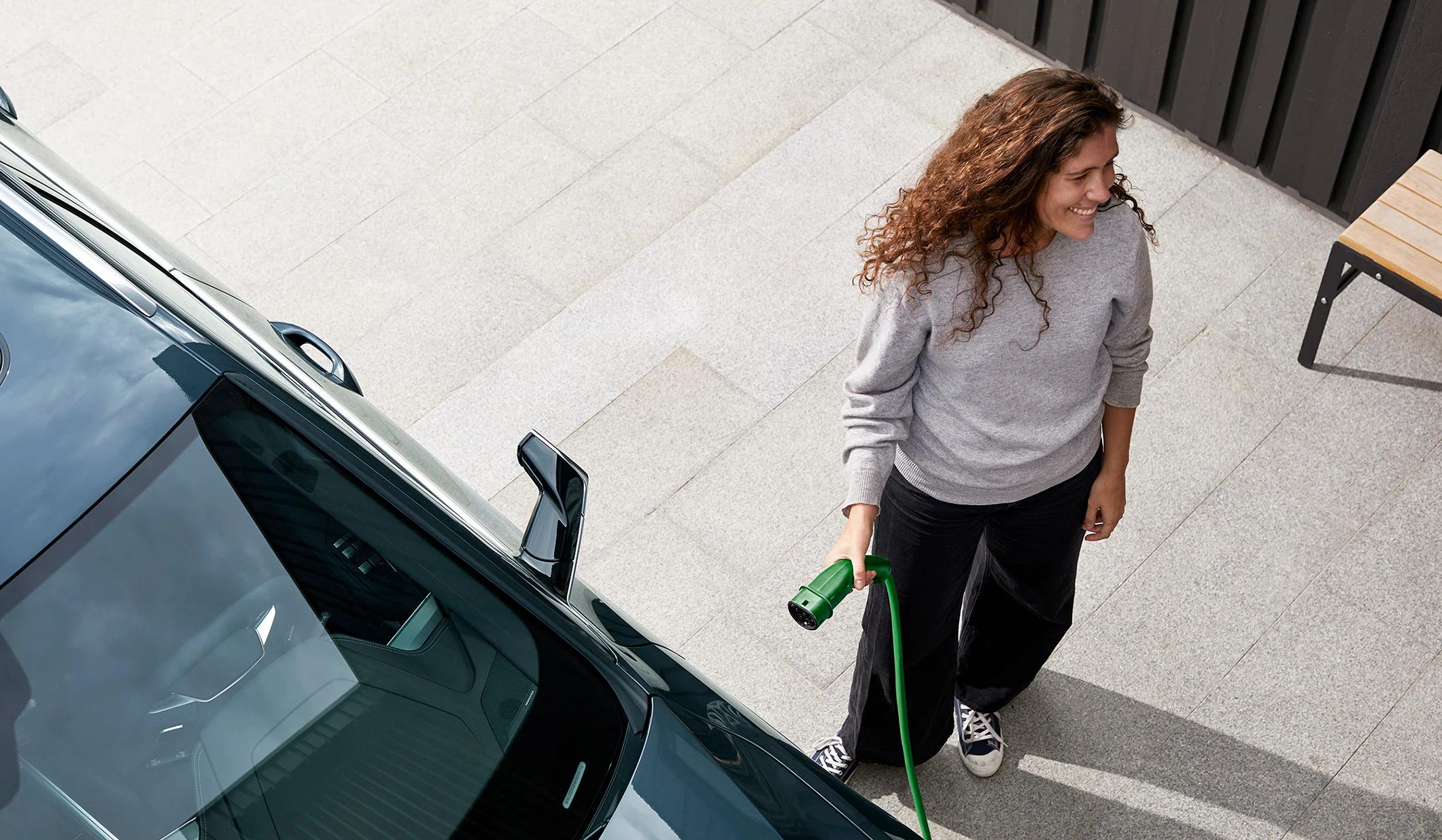 Dame som lader elbil