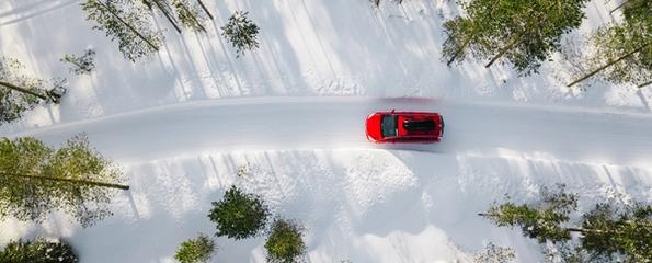En rød bil i en vinterkledd skog
